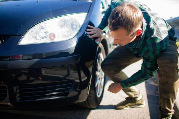 Olgun adam arabasını üzerinde çizikler arayan bir close-up.