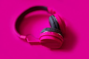 Pembe kulaklık, pembe arka planda izole edilmiş. .