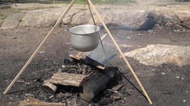 Sonbahar Ormanı 'nda kamp ateşinde konteynırda yemek pişiren çift.