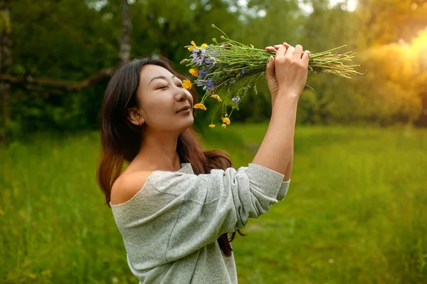 Yeşil Çimlerde Bir Buket Kır Çiçeğiyle Özgür Asyalı Kadın — Stok fotoğraf