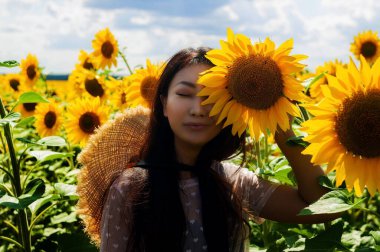 Genç Asyalı Kadın Ayçiçeği tarlasında iyi eğlenceler