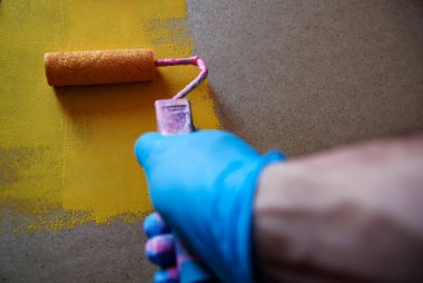 Sarı boyalı teneke kutunun üzerinde yuvarlanan kadın el ele tutuşuyor.