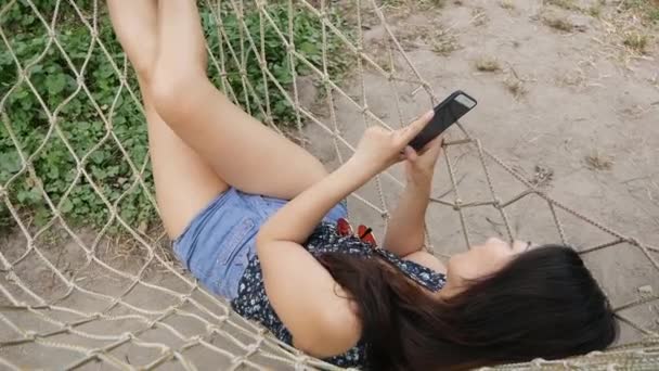 Jeune Femme Détendue Regardant Téléphone Portable Dans Hamac — Video