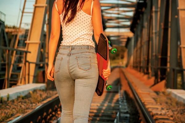 Kvinnan Jeans Bär Skateboard Stan Sidewalk — Stockfoto