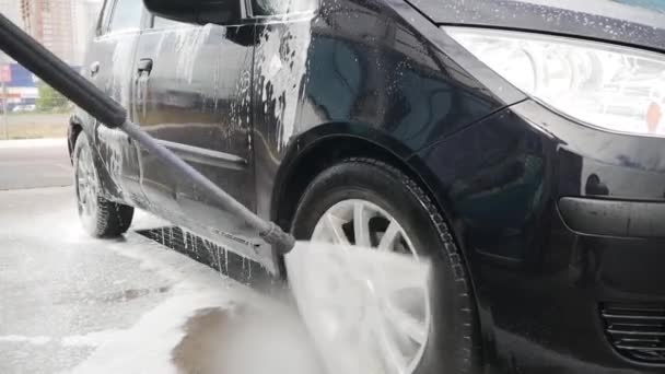 Homem Lava Carro Com Uma Água Jato Uma Espuma Alta — Vídeo de Stock