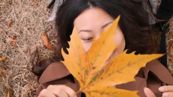 Happy Asian Woman Holding Yellow Leaf Autumn Park — Stock Video