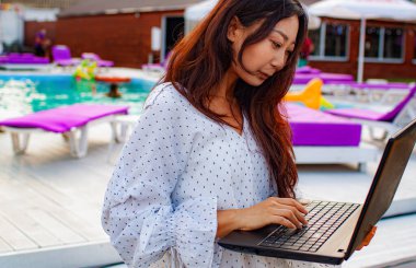 Genç Asyalı Kadın Lüks Tatilde Dizüstü bilgisayar kullanıyor