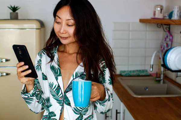 Glimlachen Aziatische Vrouw Met Smartphone Keuken Ochtend — Stockfoto