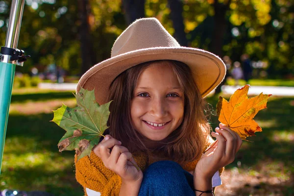 Happy Smiling Girl Playing With Autumn Leaves In The Park