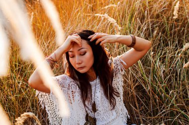 Güneşli bir tarlada gün batımında güzel bir kadının portresi..