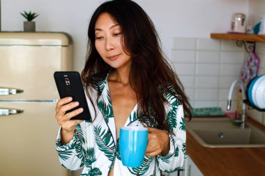 Mutfakta Cep Telefonu Kullanan Karışık Irk Kadını