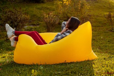 Genç bir kadın parkta bir koltukta dinleniyor..