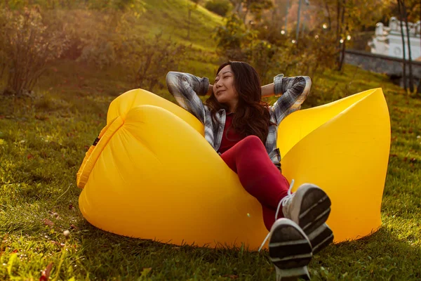 年轻女子躺在公园里的空气沙发上休息 — 图库照片