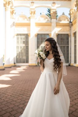 mutlu güzel gelin düğün makyajı ve saç gelin gün gülümseyerek ve damat için bekliyor. Düğün için son hazırlık ve sunuş çekici yeni evli kadın var. çok güzel bir gelin. mutlu zengin gelin.