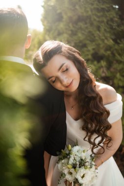 Mutlu çift dışarıda fotoğraf çekerken, öpüşürken. Genç damat ve gelin evleniyor, gülümsüyor, eğleniyor, fotoğraf çekiyor. Mutluluk ve aile ilişkileri kavramı.