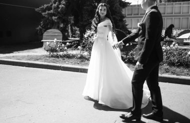 Gelin ve damat parkta kucaklaşıyor, siyah ve beyaz fotoğraf. 