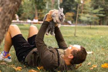 Paskalya. Genç adam bir tavşanla doğada dinleniyor..