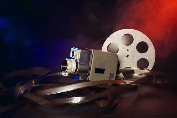 retro 8 mm movie camera with a reel of film in smoke. dark background