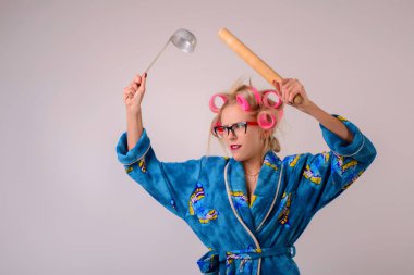 Bir sabahlık ve curlers bir kepçe ve battledore çılgın ev kadını çığlık.
