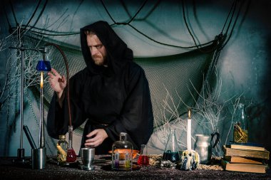 Simyacı laboratuvar olarak çalışır. Ortaçağ bilim adamı bir felsefi taş elde etmek için bir deney yapar. Cadılar Bayramı