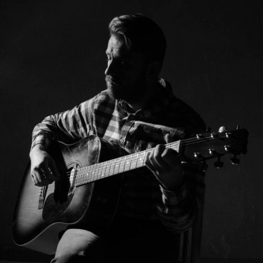 Caucasian bearded male musician playing guitar on stage, focus on hand. black and white. clipart