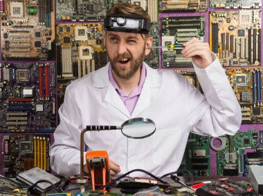 Beyaz önlük onun laboratuvar masasında otururken kulağına bir tornavida tutan komik mühendisi.