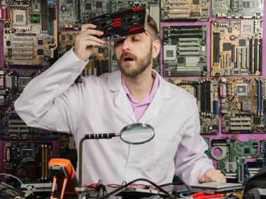 Genç elektronik mühendisi alnına bir bilgisayarla laboratuvar masasında otururken soğutucu soğur