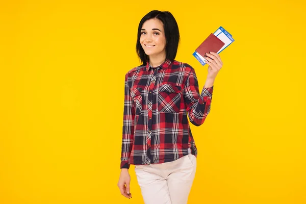 Young smiling excited woman student holding passport boarding pass ticket isolated on yellow background. Education in university college abroad. Air travel flight - Image