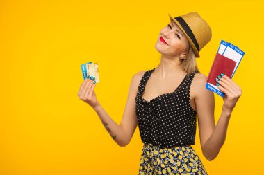 Genç gülümseyen kadın öğrenci pasaport boarding pass bilet ve kredi kartı üzerinde sarı arka plan izole tutan heyecanlı. Hava seyahat uçuş - görüntü