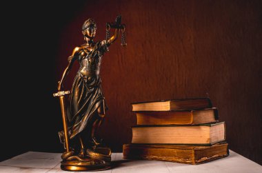 Beyaz ahşap bir masa yanında bir yığın üzerinde Themis heykelcik duruyor eski kitaplar. Terazi hukuk avukat iş kavramı. -Görüntü