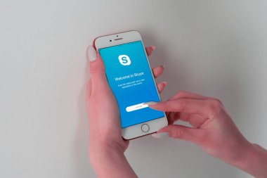 Ekranda Skype uygulamasıyla Apple IPhone 7 tutan kadın.