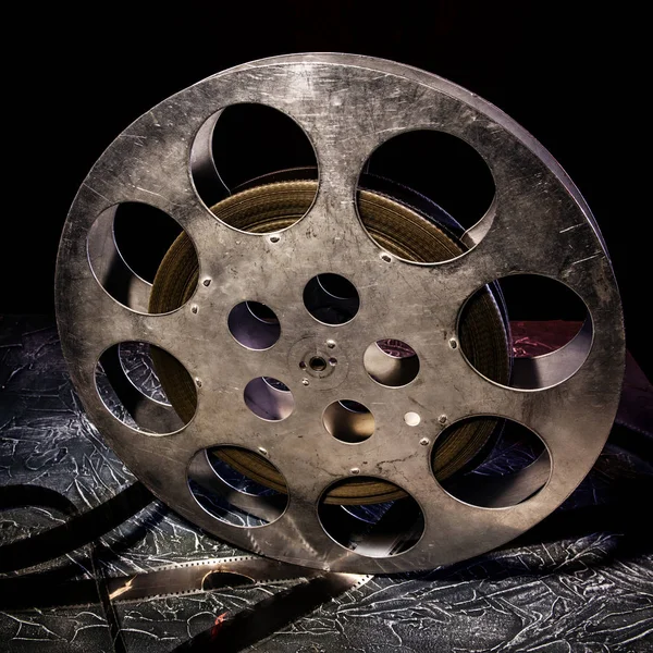 stock image 35 mm film reel with dramatic lighting on a dark background