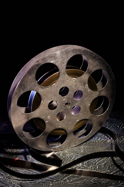 35 mm film kołowrotek z dramatyczne oświetlenie na ciemnym tle — Zdjęcie stockowe