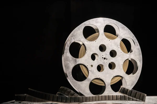 stock image 35 mm film reel with dramatic lighting on a dark background