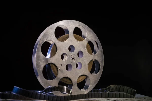 stock image 35 mm film reel with dramatic lighting on a dark background