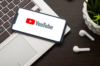 iPhone X ekranındaki Youtube logosu dizüstü bilgisayarın anahtarına yerleştirilir