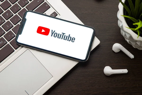 iPhone X ekranındaki Youtube logosu dizüstü bilgisayarın anahtarına yerleştirilir