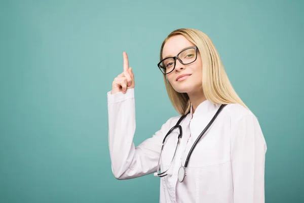 Stetoskop copyspase işaret gülümseyen genç tıp doktoru kadın. — Stok fotoğraf