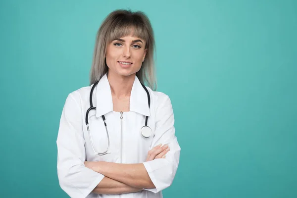 Gülümseyen genç kadın doktor ayakta bir steteskop ile — Stok fotoğraf