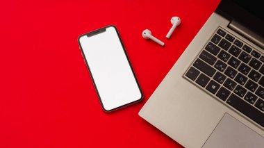 Tula, Rusya - 24 Mayıs 2019: Dizüstü bilgisayarlı kırmızı arka plan da Apple iphone X ve Airpods.
