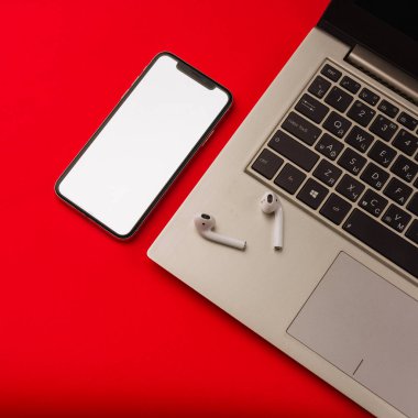 Tula, Rusya - 24 Mayıs 2019: Dizüstü bilgisayarlı kırmızı arka plan da Apple iphone X ve Airpods.