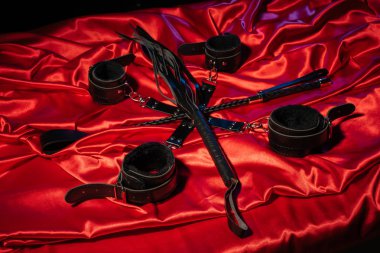 BDSM kıyafeti üst görünümü. Esaret ve kırbaç kırmızı keten üzerinde şaplak geçti. Yetişkin Seks Oyunları. Kinky yaşam tarzı.