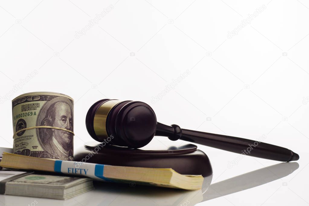 Judge's gavel and packs of dollars and euro banknotes on a white background