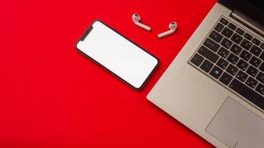Tula, Rusya - 24 Mayıs 2019: Dizüstü bilgisayarlı kırmızı arka plan da Apple iphone X ve Airpods.