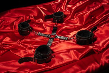 BDSM kıyafeti üst görünümü. Kırmızı keten üzerinde esaret geçti. Yetişkin Seks Oyunları. Kinky yaşam tarzı.