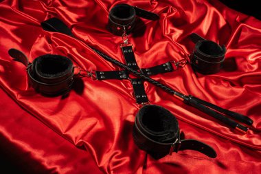 BDSM kıyafeti üst görünümü. Kırmızı keten üzerinde esaret ve şaplak. Yetişkin Seks Oyunları. Kinky yaşam tarzı.