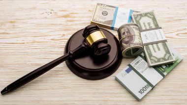 Top view Judge's gavel and packs of dollars and euro banknotes on a white wooden table clipart