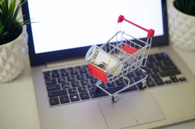 Online alışveriş konsepti. Paralı bir araba dizüstü bilgisayarın klavyesinde..