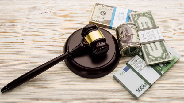 Top view Judge's gavel and packs of dollars and euro banknotes on a white wooden table — Stock Photo, Image
