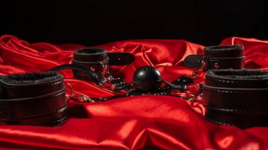 BDSM kıyafeti. Kırmızı keten üzerinde esaret ve gag topu. Yetişkin Seks Oyunları. Kinky yaşam tarzı.